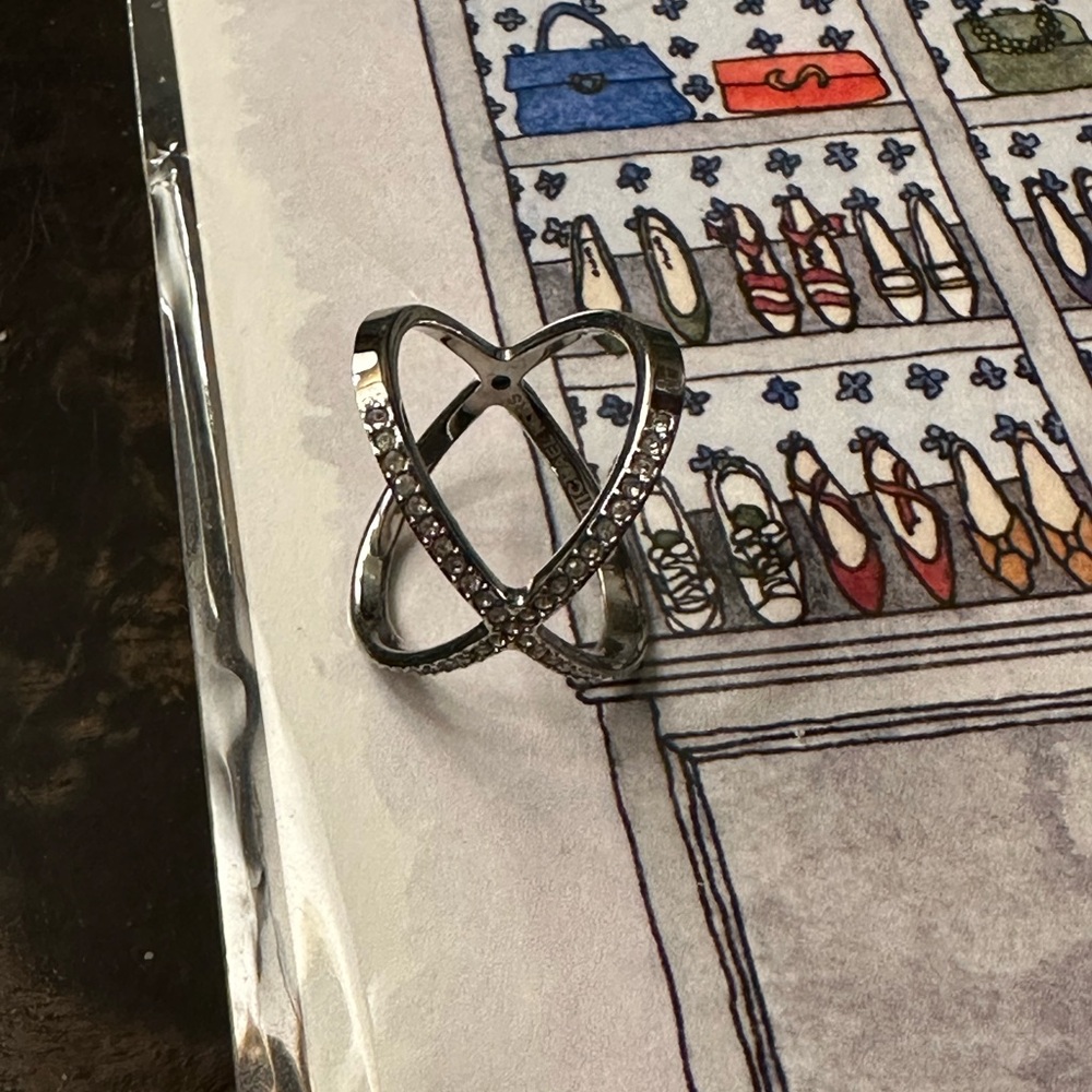Michael Kors cross cross silver ring with stones across the top.